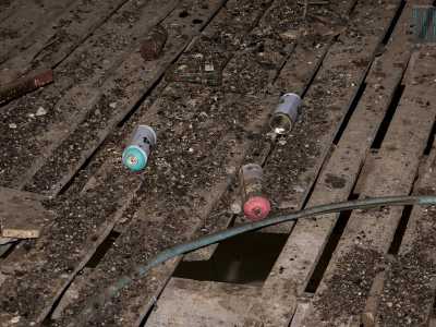 Torniamo verso la rampa per avanzare al terzo piano, dove tra un tappeto di vetri rotti, chiodi, tubi di gomma e pezzi di intonaco balzano all'occhio delle bombolette spray usate